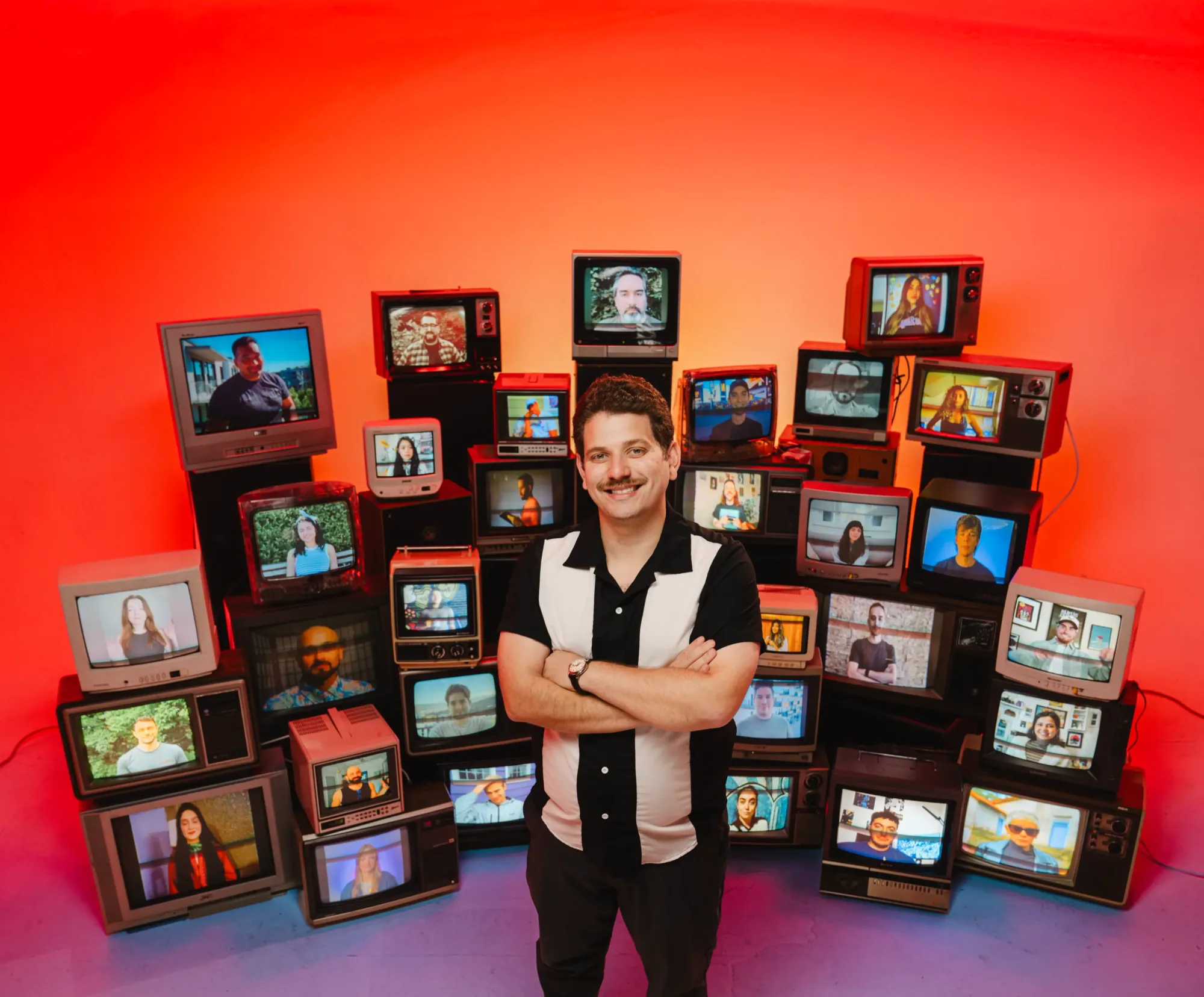 The Content Forge team on a wall of retro TVs behind Isaac