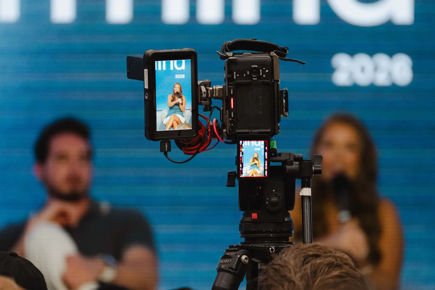 A camera rig filming a fireside chat at the NYC Mastermind, the speaker framed on the monitor
